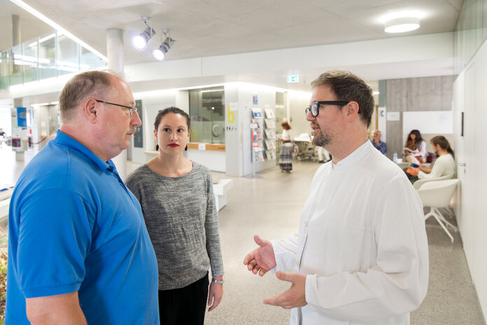 Besprechung in der Klinik, © Krebsinformationsdienst, DKFZ; Foto: Tobias Schwerdt Patient, Tochter und Arzt besprechen sich in der Klinik