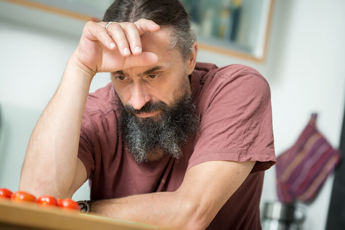 Appetitlosigkeit, © Krebsinformationsdienst, DKFZ; Foto: Tobias Schwerdt Mann sitzt am Tisch und stützt sich den Kopf.